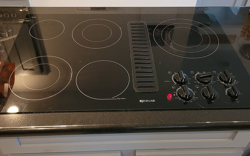 Heating Element Repair in Plano, TX Jenn-Air electric cooktop with control knobs and heating zones after repair, all elements working properly.