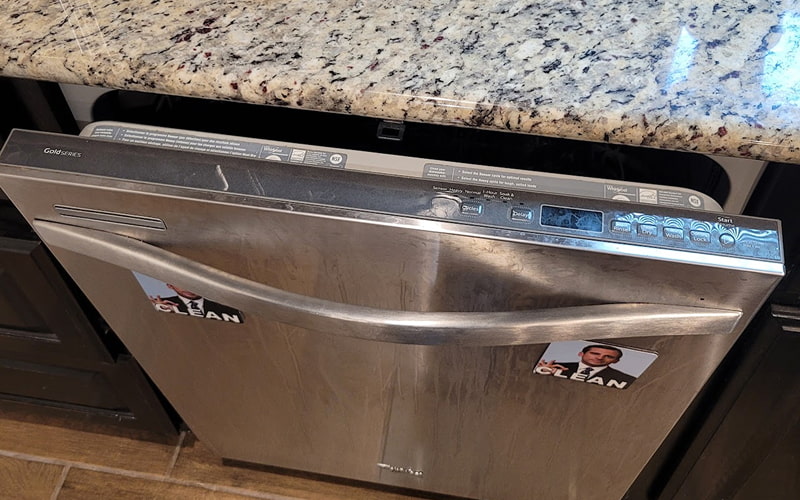 Technician repairing dishwasher in modern kitchen in Plano TX