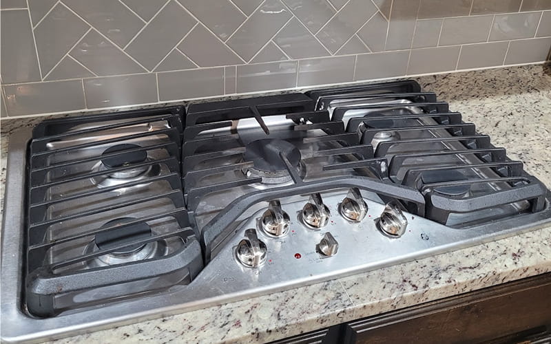 Cooktop Not Working? Fast & Reliable Cooktop Repair in Plano. Technician repairing an electric cooktop in Plano, Texas